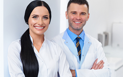 Two dentists smiling while at work